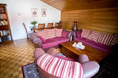 a living room with two couches and a table at Apartma Kamra15 in Mežica