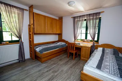 a bedroom with two beds and a desk and a bed at Prijeten sončen apartma v objemu Pohorja in Zgornje Hoče