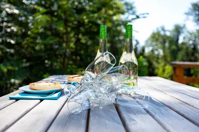 two bottles of wine sitting on a wooden table at Prijeten sončen apartma v objemu Pohorja in Zgornje Hoče