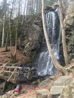 a bike on a bridge next to a waterfall at Prijeten sončen apartma v objemu Pohorja in Zgornje Hoče