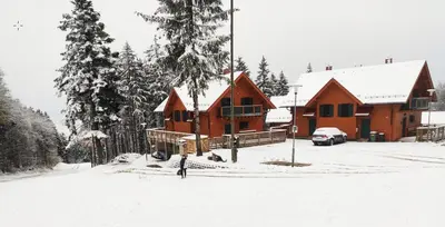 a house in the snow with a car parked in front at Prijeten sončen apartma v objemu Pohorja in Zgornje Hoče