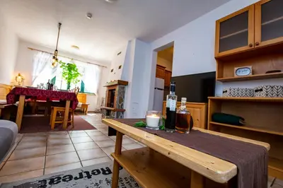 a kitchen and living room with a table with a candle at Prijeten sončen apartma v objemu Pohorja in Zgornje Hoče