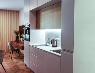 a kitchen with white cabinets and a counter top at JU3 Apartments in Ljubljana