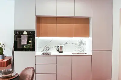 a kitchen with white cabinets and a sink at JU3 Apartments in Ljubljana