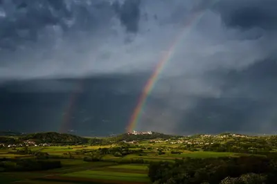 a rainbow in the sky over a field at Fine Rooms Vipava in Vipava