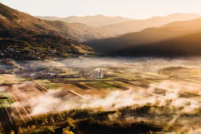 a foggy valley with a town and mountains at Fine Rooms Vipava in Vipava