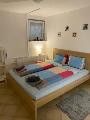 a bedroom with a large bed with blue and red at Room Julija in Žirovnica