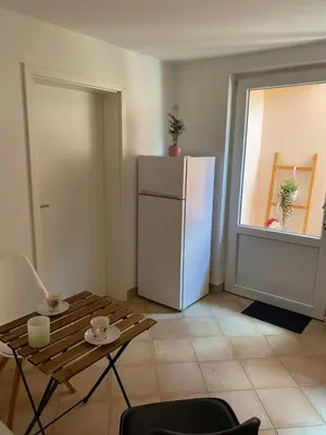 a kitchen with a white refrigerator and a table at Room Julija in Žirovnica