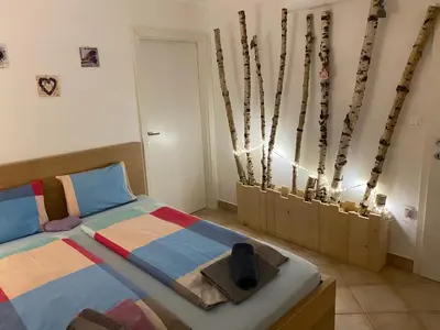 a bedroom with a bed and some twig poles at Room Julija in Žirovnica