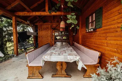 a table in the back of a wooden house at Cozy family place 'Hiša Grozdek' - Gruškovec 40A in Gruškovec