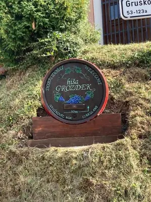 a sign sitting in the grass in a field at Cozy family place 'Hiša Grozdek' - Gruškovec 40A in Gruškovec