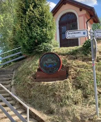 a sign in front of a building on a hill at Cozy family place 'Hiša Grozdek' - Gruškovec 40A in Gruškovec