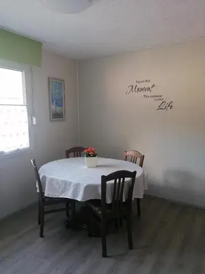 a dining room table with a white tablecloth and chairs at APARTMAJI VALTER in Srpenica