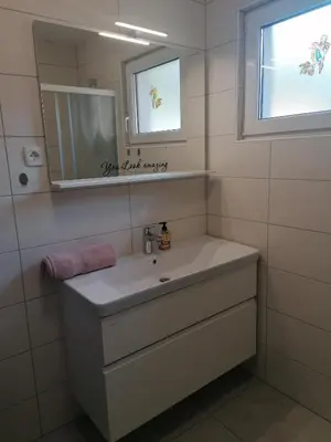 a bathroom with a white sink and a mirror at APARTMAJI VALTER in Srpenica