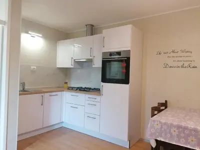 a kitchen with white cabinets and a stove top oven at APARTMAJI VALTER in Srpenica