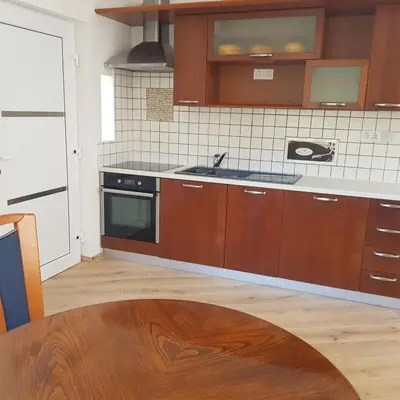 a kitchen with wooden cabinets and a stove top oven at Trg Mozirje in Mozirje