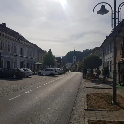 a street with cars parked on the side of the road at Trg Mozirje in Mozirje