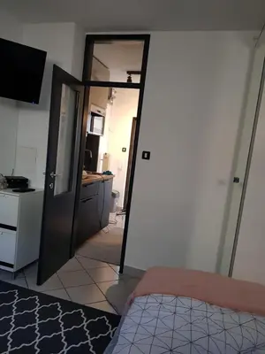 a bedroom with a door open to a kitchen with a bed at A place to relax in Ljubljana