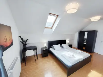 a bedroom with a bed and a table and a window at Centrally located, with castle view and 2 parkings in Bled