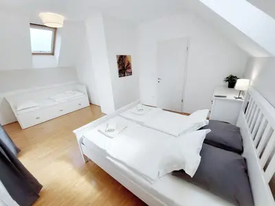a white room with a bed and a couch at Centrally located, with castle view and 2 parkings in Bled