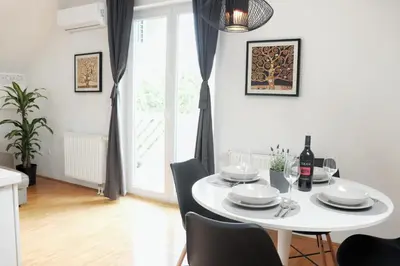 a white dining room with a white table and chairs at Centrally located, with castle view and 2 parkings in Bled