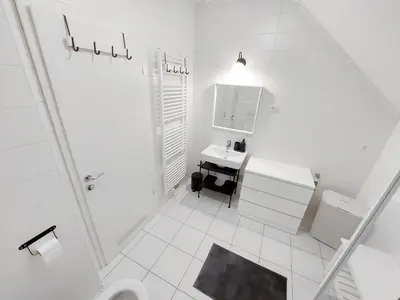 a white bathroom with a sink and a toilet at Centrally located, with castle view and 2 parkings in Bled