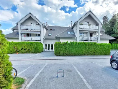 a large white house with a parking lot at Centrally located, with castle view and 2 parkings in Bled