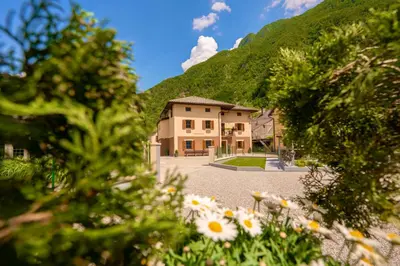 a house in the mountains with flowers in the foreground at Relax House Soča in Bovec