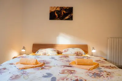 a bedroom with a large bed with two pillows at Relax House Soča in Bovec