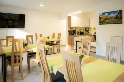 a dining room and kitchen with yellow tables and chairs at Relax House Soča in Bovec