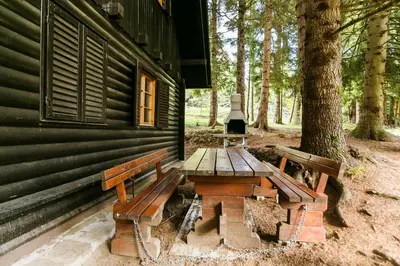 a picnic table and bench outside of a cabin at Chalet Liza & Rozi in Zgornja Ložnica