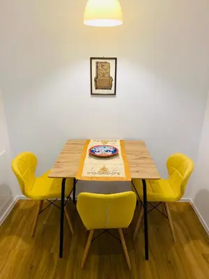 a dining room table with yellow chairs and a plate on it at Gogalova Apartments in Ljubljana