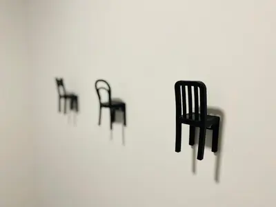 a row of black chairs on a white wall at Gogalova Apartments in Ljubljana