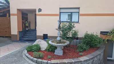 a fountain in a garden in front of a building at Hiša Bizjak in Kranj