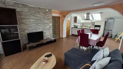 a living room with a couch and a dining room at Hiša Bizjak in Kranj