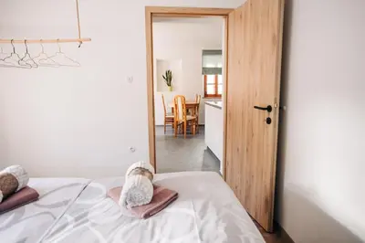 a bedroom with a bed and a dining room at Štekner house Apartma in Ljubno
