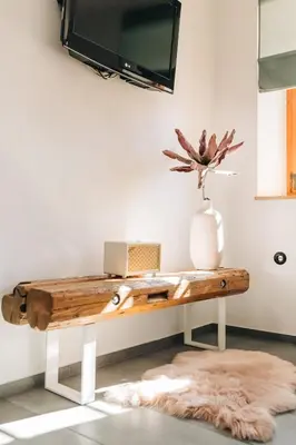 a living room with a table with a tv on the wall at Štekner house Apartma in Ljubno