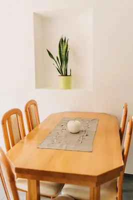 a wooden table with chairs and a plant on it at Štekner house Apartma in Ljubno