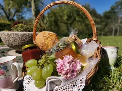 a picnic basket filled with food and vegetables on a table at Apartment river Nadiža Podbela in Podbela