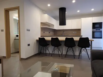 a kitchen with black chairs and a counter in a room at Apartment river Nadiža Podbela in Podbela