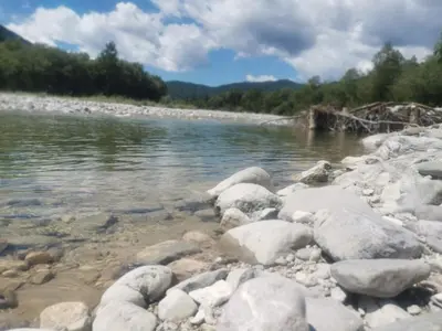 a group of rocks on the shore of a river at Apartment river Nadiža Podbela in Podbela
