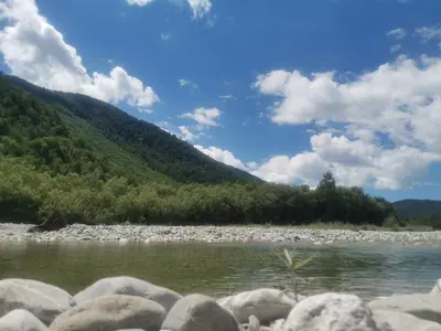a river with rocks in front of a mountain at Apartment river Nadiža Podbela in Podbela