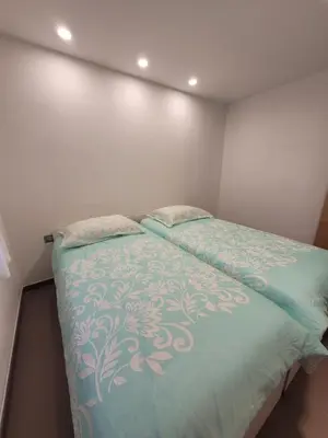 a bedroom with a bed with a green comforter at Apartment river Nadiža Podbela in Podbela