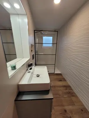 a bathroom with a white sink and a mirror at Apartment river Nadiža Podbela in Podbela