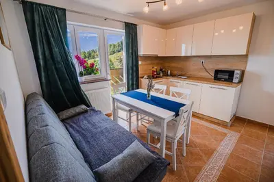 a living room with a couch and a table and a kitchen at Eko Pony Ranch Ogrizek in Podčetrtek