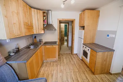 a kitchen with wooden cabinets and a counter top at Eko Pony Ranch Ogrizek in Podčetrtek