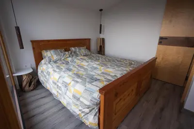 a bedroom with a bed with a wooden floor at Vineyard cottage Sonce in Šentvid pri Stični