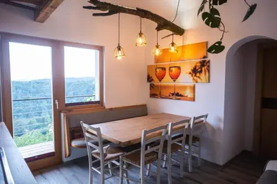 a dining room with a table and chairs and a window at Vineyard cottage Sonce in Šentvid pri Stični