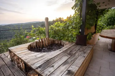a wooden deck with a fire pit on a balcony at Vineyard cottage Sonce in Šentvid pri Stični