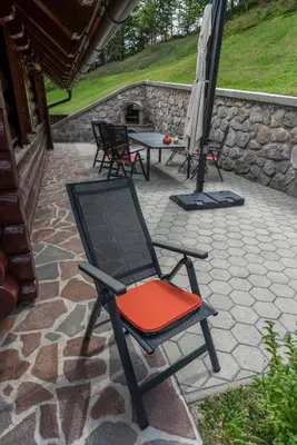 a chair on a patio with a table and an umbrella at Chalet Ajda in Bohinj
